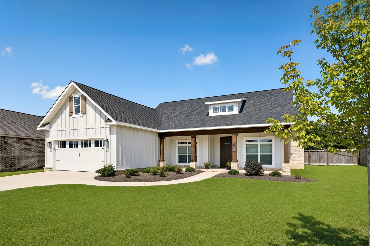 Well-lit real estate photo of a white farmhouse-style home exterior showcasing the property at its best