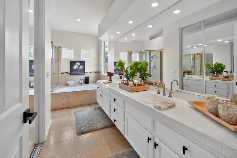 Bathroom double vanity with tile counters and a soaking tub