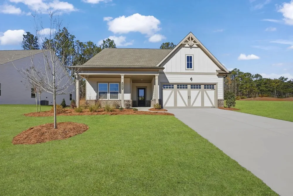 Single-story home with a covered front porch and freshly landscaped yard, prepared for a real estate listing