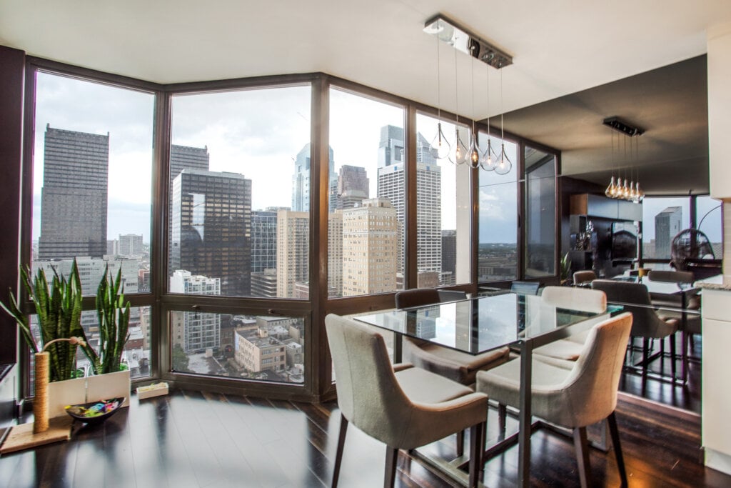 Interior photo of a dining room with large windows looking over the city of Philadelphia.