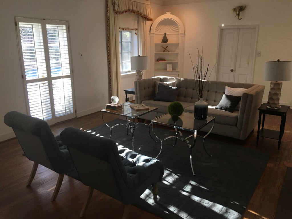 Photo of a living room with a sofa opposite two chairs with a glass tables in the middle. 