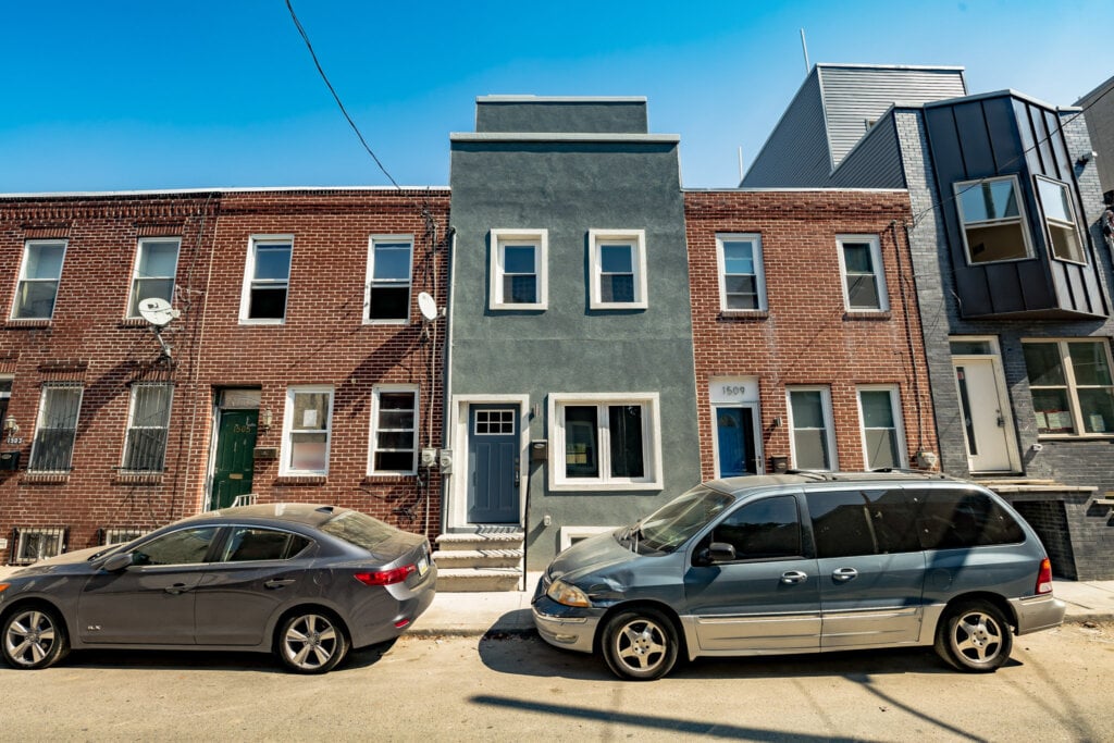 Street view of a home with cars blocking the view. - HomeJab