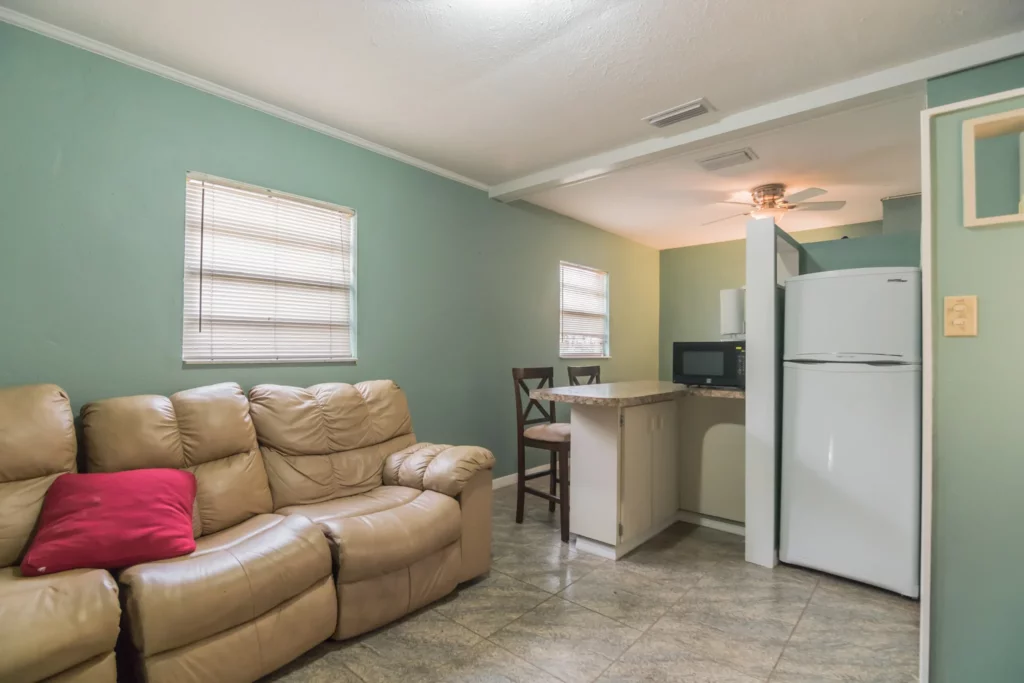 Green kitchen with a sofa against the wall. - HomeJab