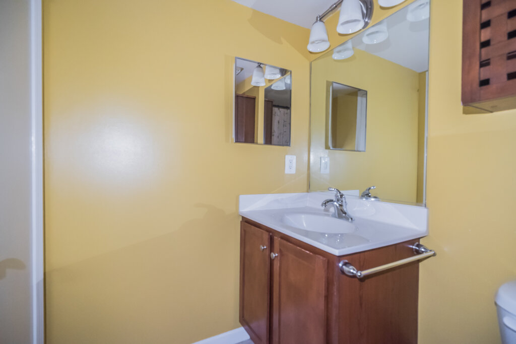 Picture of a small bathroom with yellow walls and small sink. - HomeJab