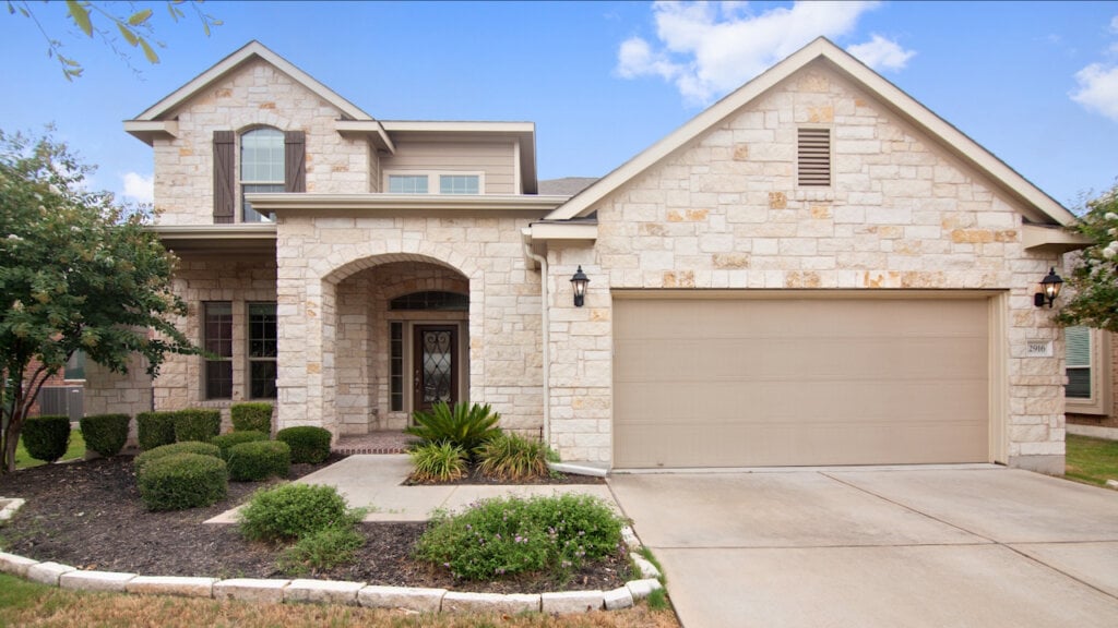 Large stone covered home filtered to look brighter and using blue sky replacement.