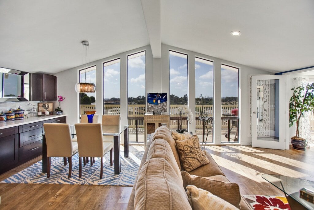 Large dining area with wood floors and large picture windows.