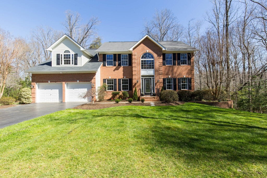 Curbside real estate photo of a two story home and large front yard.