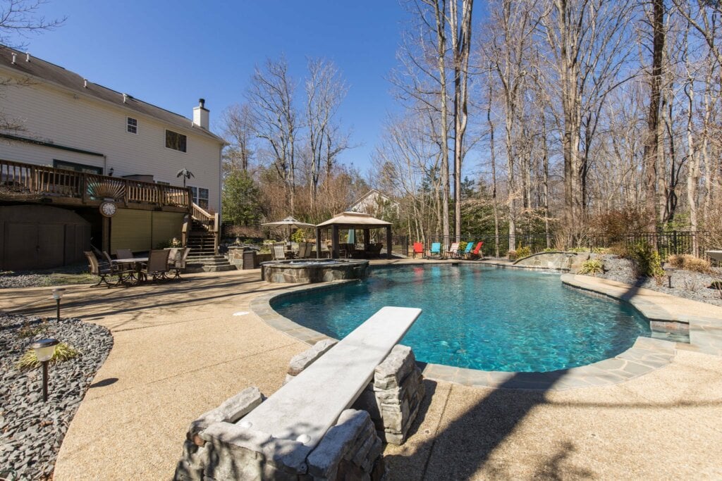 Photo of the same back yard but from a new angle behind the diving board.