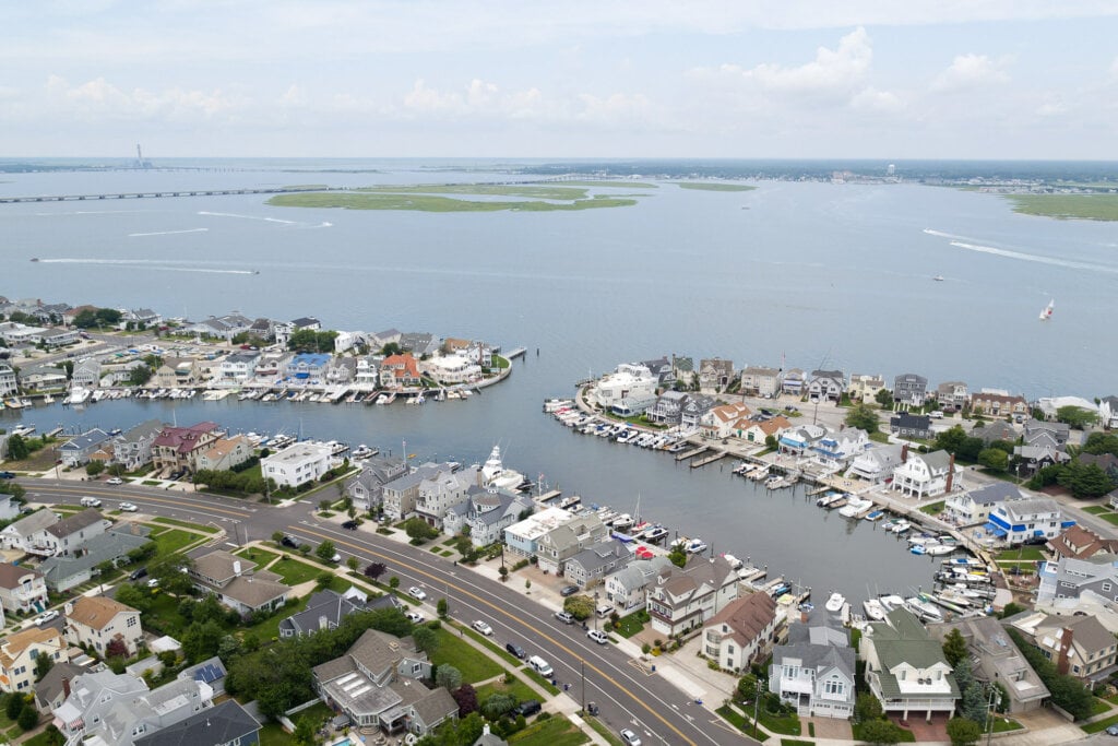 Areal drone photograph of a neighborhood with a port overlooking a bay.