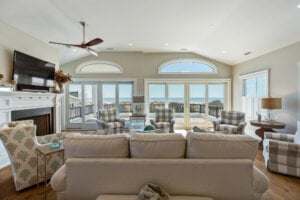 Interior photo of a family room with with high ceiling and glass doors looking over the back patio. 
