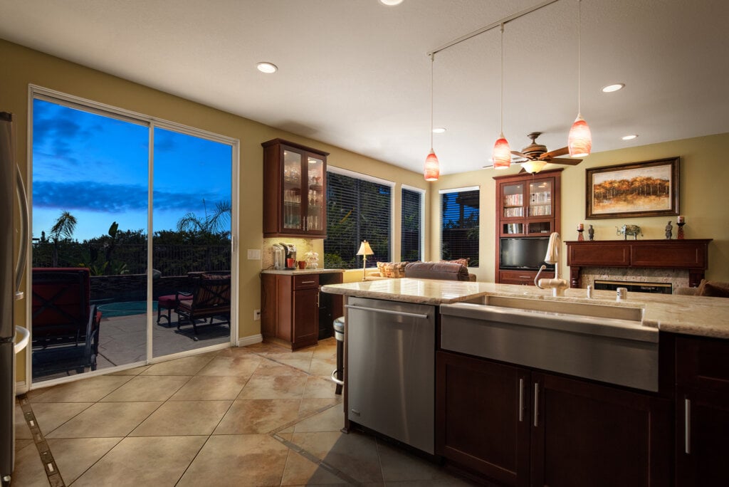 Large open kitchen with center island, farm house sink and tiled floors.