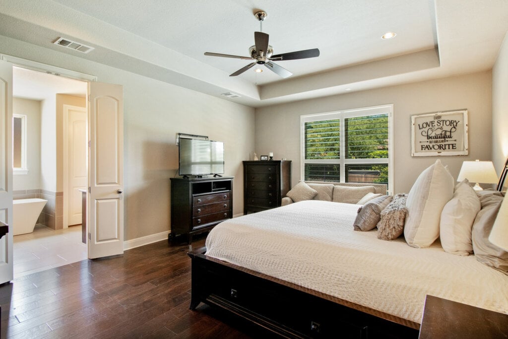 Beige bedroom with wood floors and ceiling fan taken by a HomeJab professional photographer.