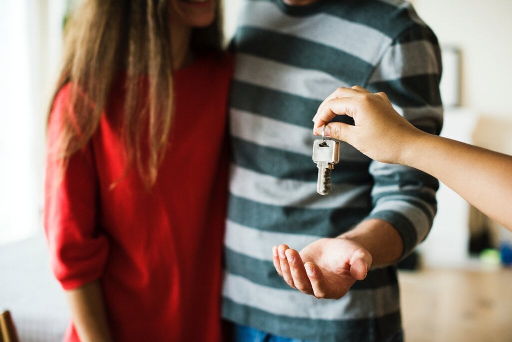 Young couple being handed the keys to a new home. - HomeJab