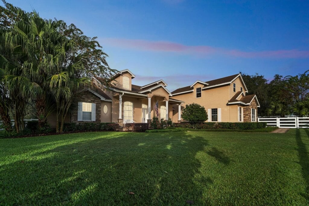 Exterior photo of a two story home with a large front yard using virtual dusk.