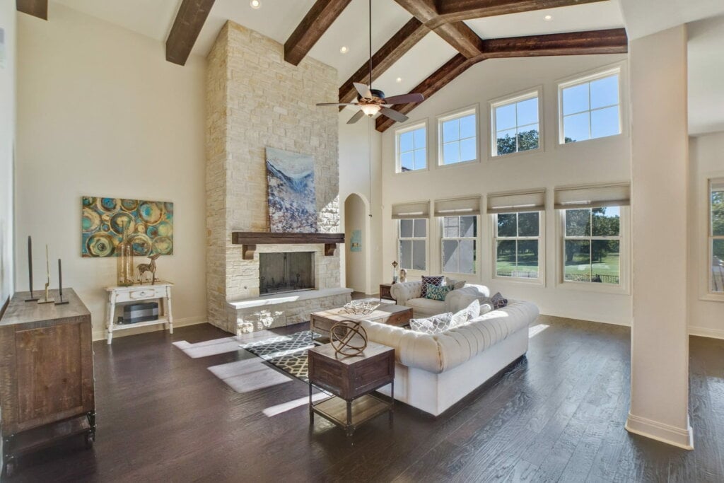 Interior photo of a spacious living room with wood floor and high ceiling. 
