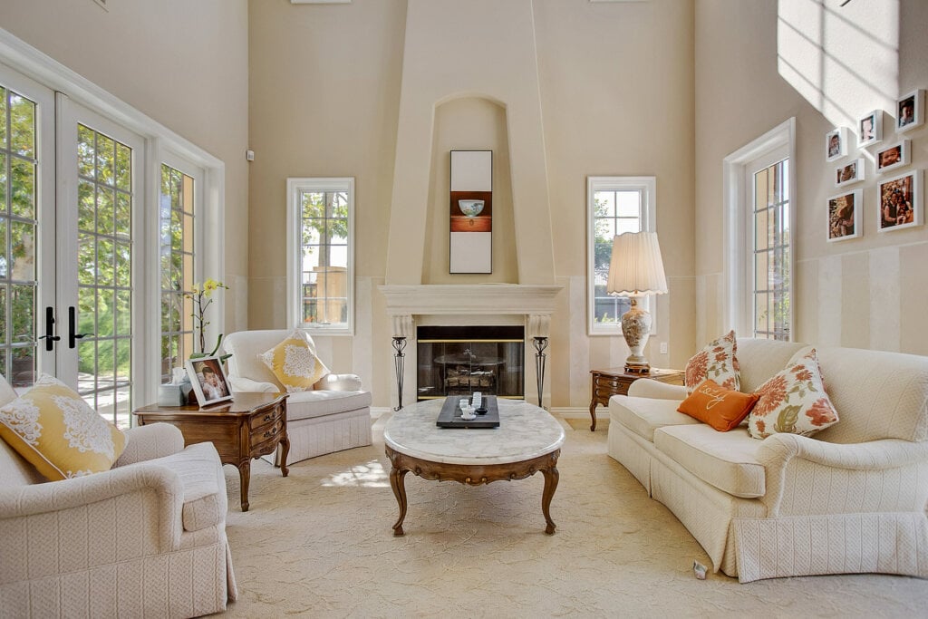 Interior photo of a large living room with cream colored walls, sofa and chairs.