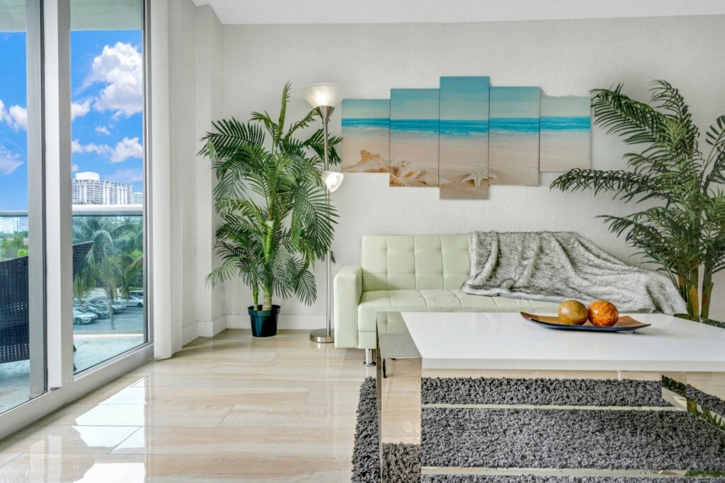 Living room of vacation rental with marble floor and large window. - HomeJab