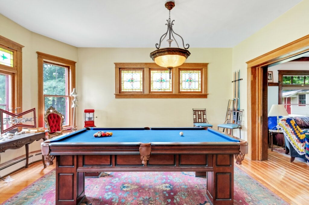 Billiard room with antique lighting and wood floor. - HomeJab