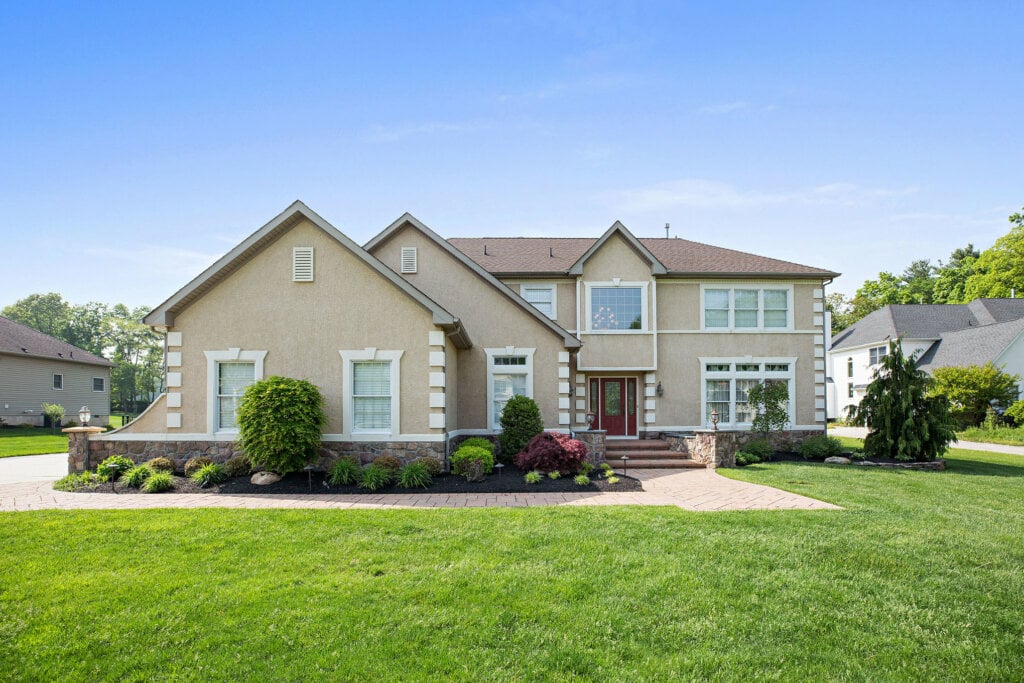 Curbside photo of a two story home and a large green front yard.