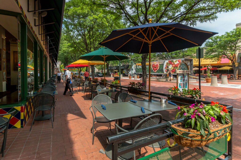 Outdoor photo of the patio dining area in a downtown neighborhood.