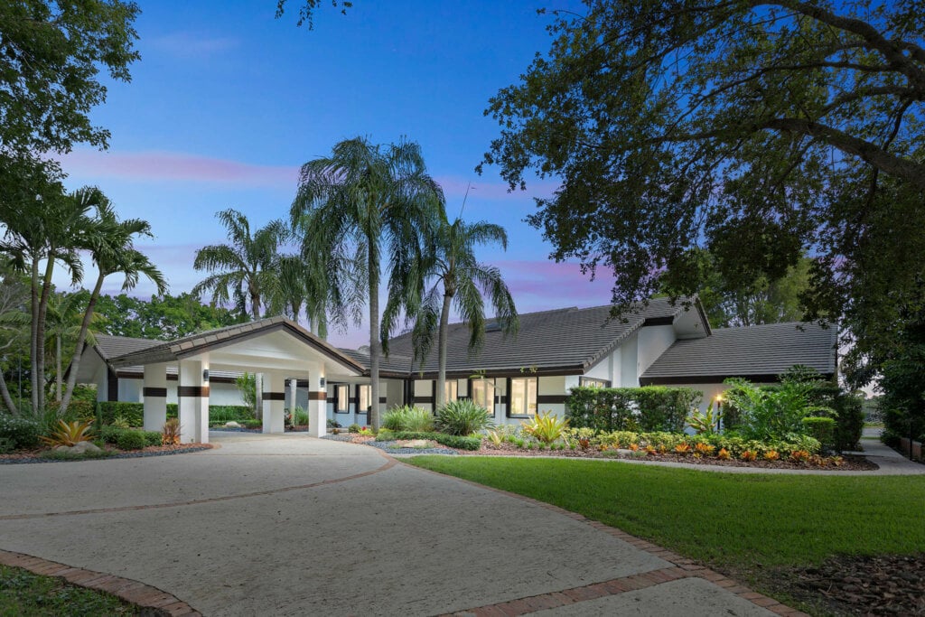 Large one story house with white walls and grey room taken at twilight.