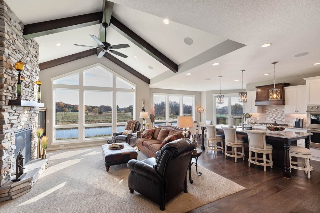 Large living room and kitchen area with seating in front of the fireplace.