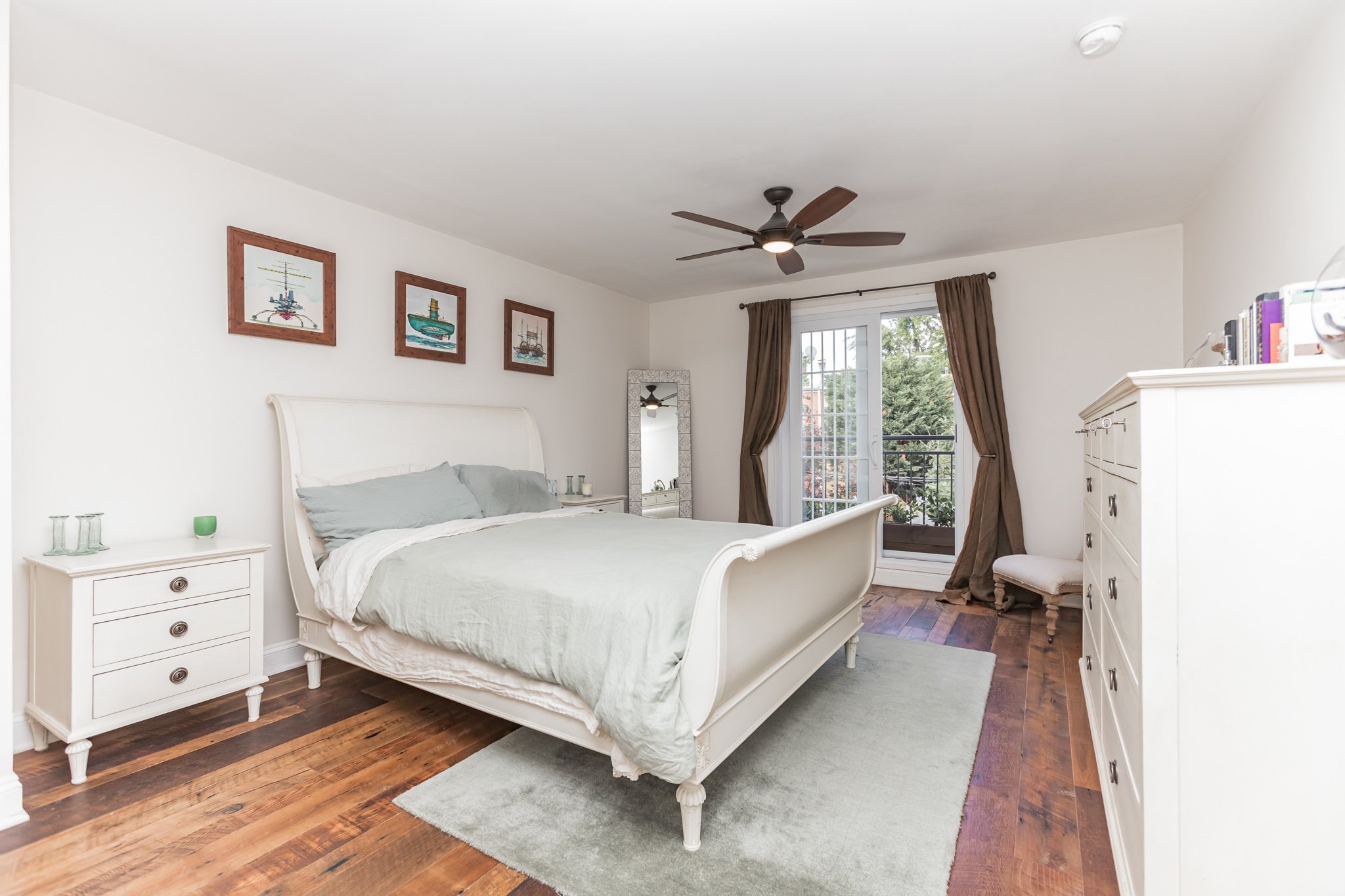 White bedroom with wood floors and grey carpet - HomeJab