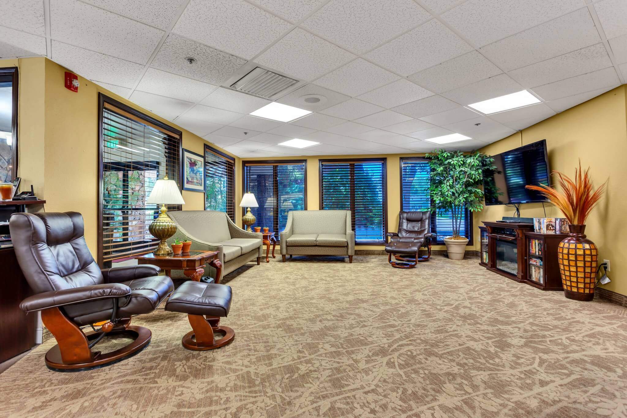 Spacious living room with seating and large windows .