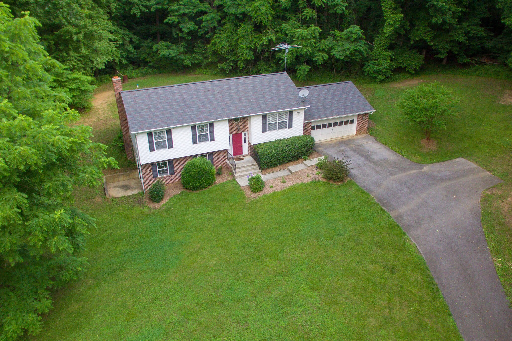 Areal photograph of a 2 story home with large yard and long driveway.